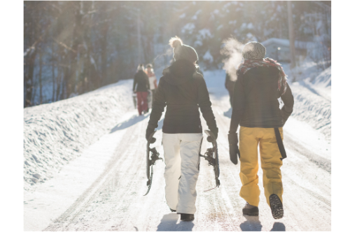 Vacances à la montagne. Homme et femme se promenant sur les pistes de ski avec les raquettes à la main