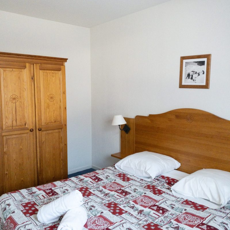 Chambre avec lit double, armoire de rangement, fenêtre